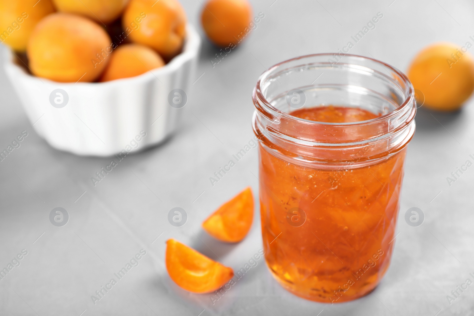 Photo of Jar with tasty apricot jam on table