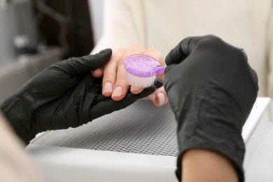 Photo of Professional manicurist working with client, closeup view