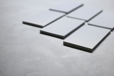 Photo of Blank business cards on light grey textured table, closeup. Mockup for design