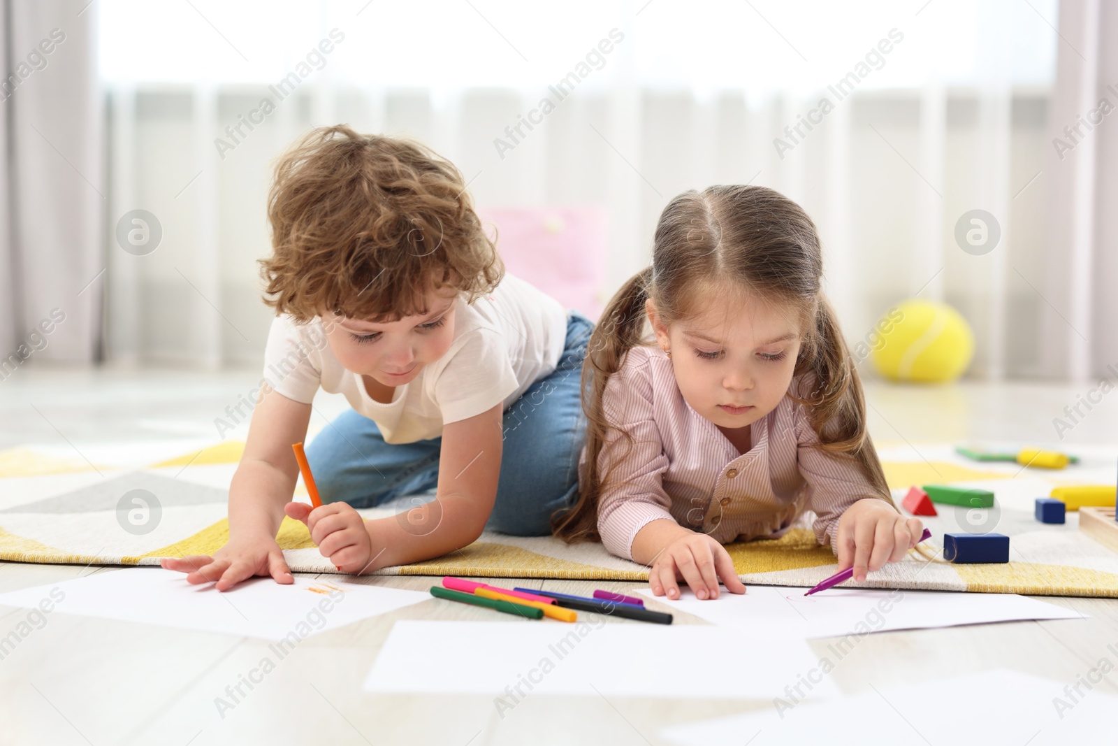 Photo of Cute little children drawing on floor in kindergarten