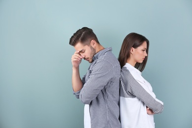 Upset young couple on color background. Relationship problems