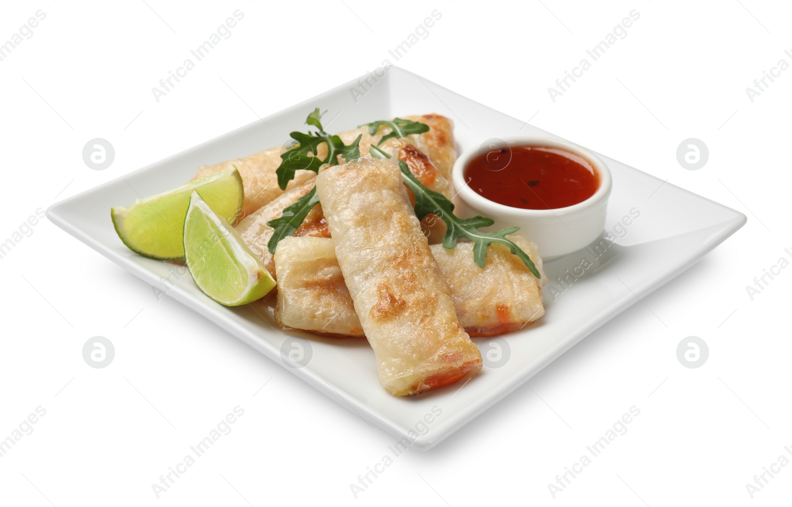 Photo of Tasty fried spring rolls, arugula, lime and sauce isolated on white