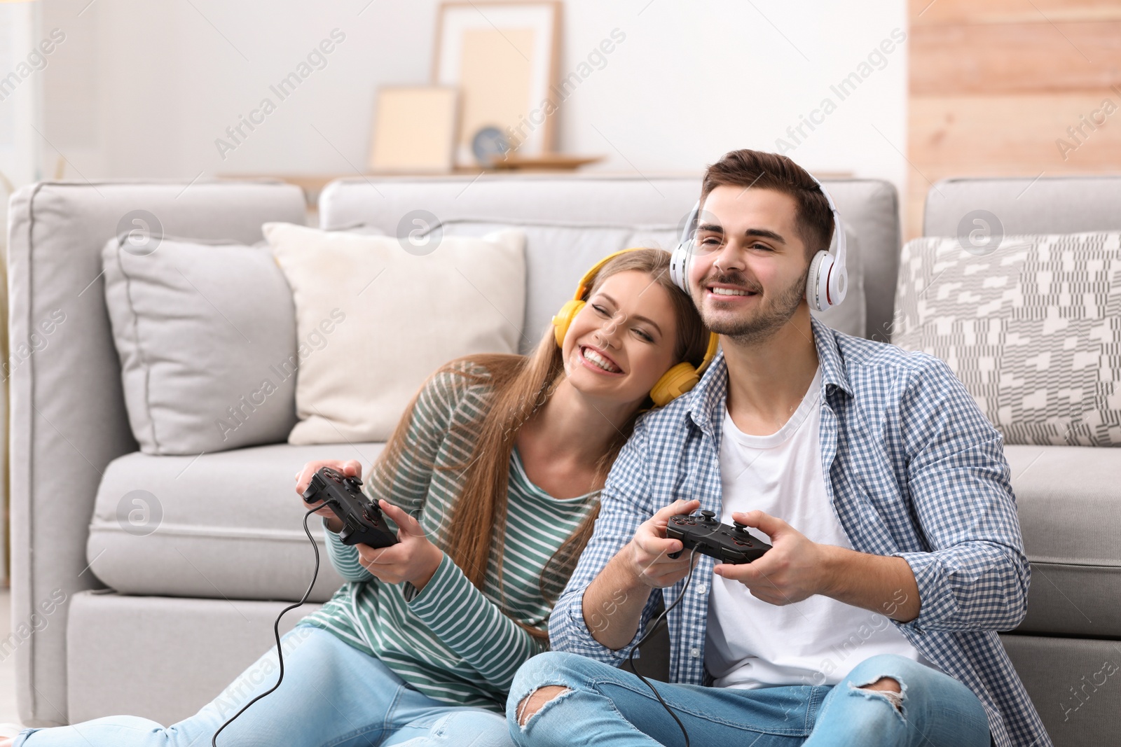 Photo of Emotional young couple playing video games at home