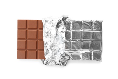 Photo of Delicious milk chocolate bar in foil on white background, top view