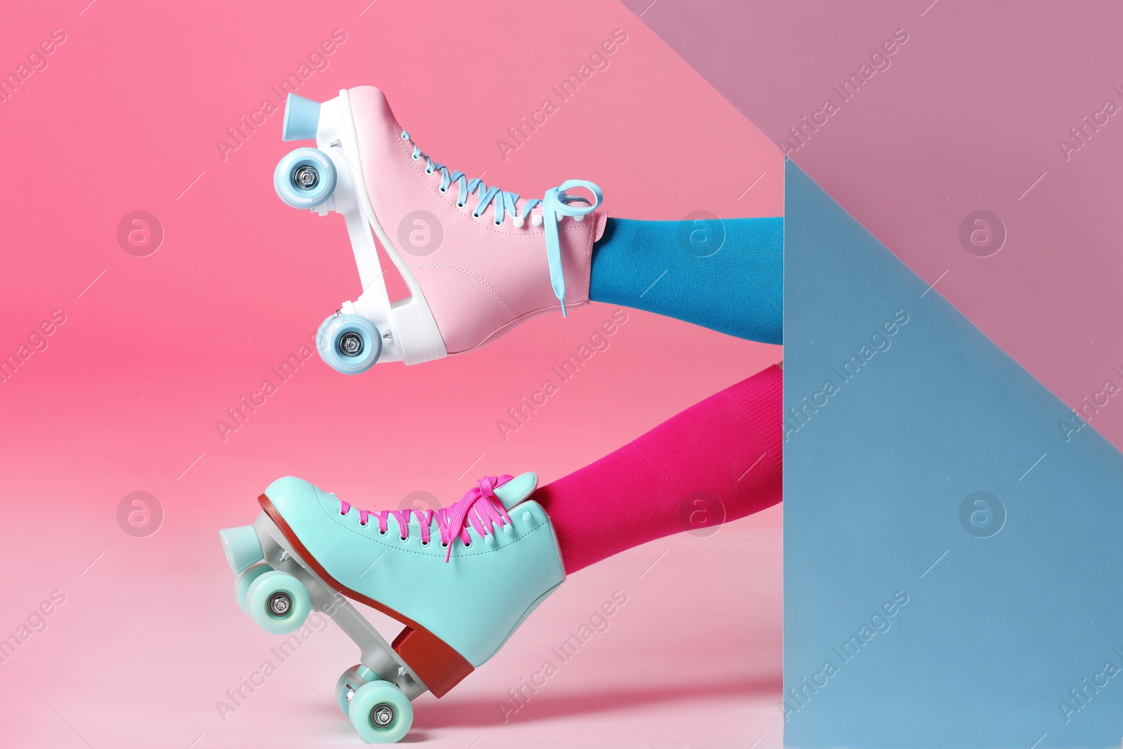 Photo of Woman with vintage roller skates on color background, closeup