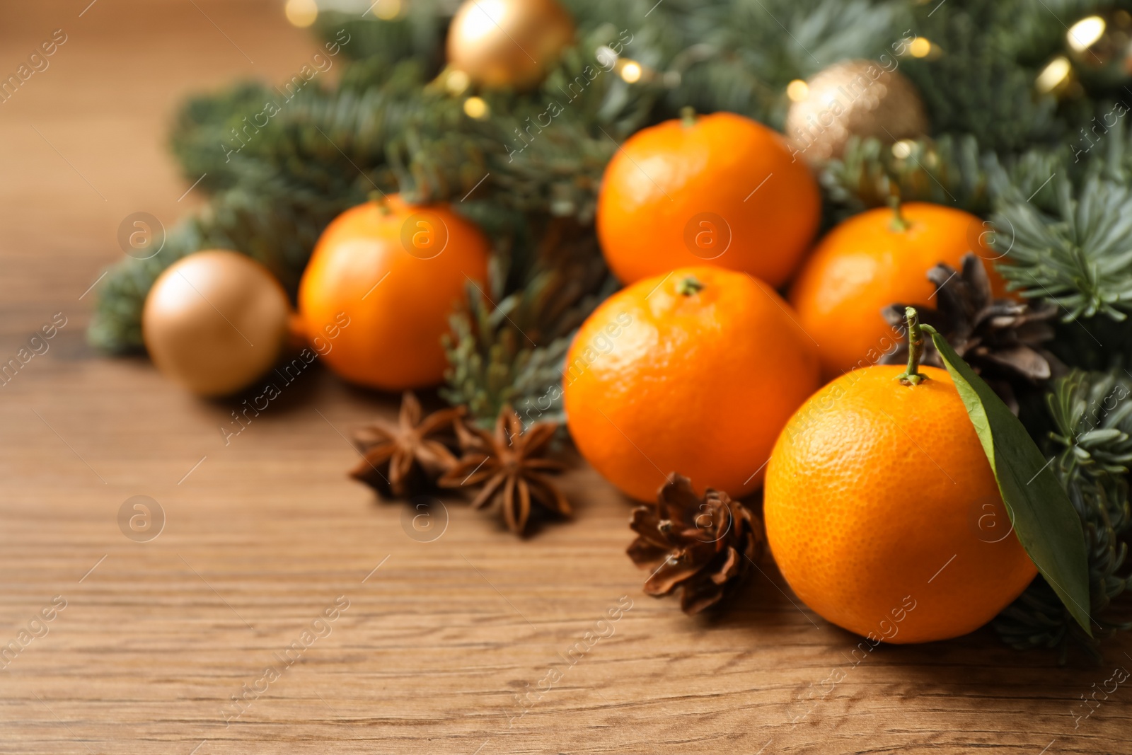 Photo of Christmas composition with tangerines on wooden table, closeup