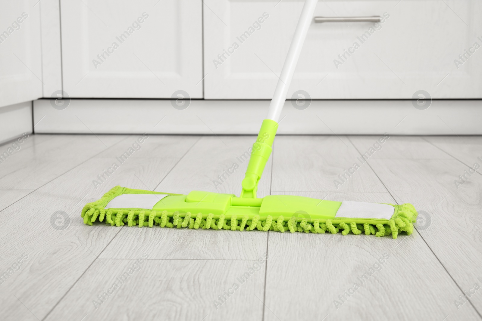 Photo of Cleaning of parquet floor with mop indoors