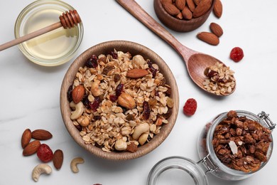 Photo of Tasty granola served with nuts and dry fruits on white table, flat lay