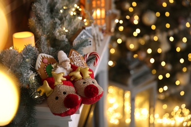 Photo of Sweets in soft slippers on fireplace, space for text. Saint Nicholas Day tradition