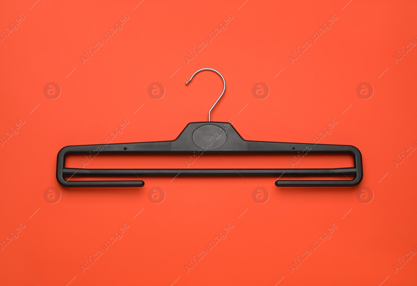 Photo of Empty clothes hanger on red background, top view