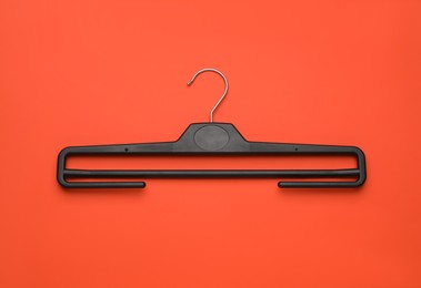 Photo of Empty clothes hanger on red background, top view