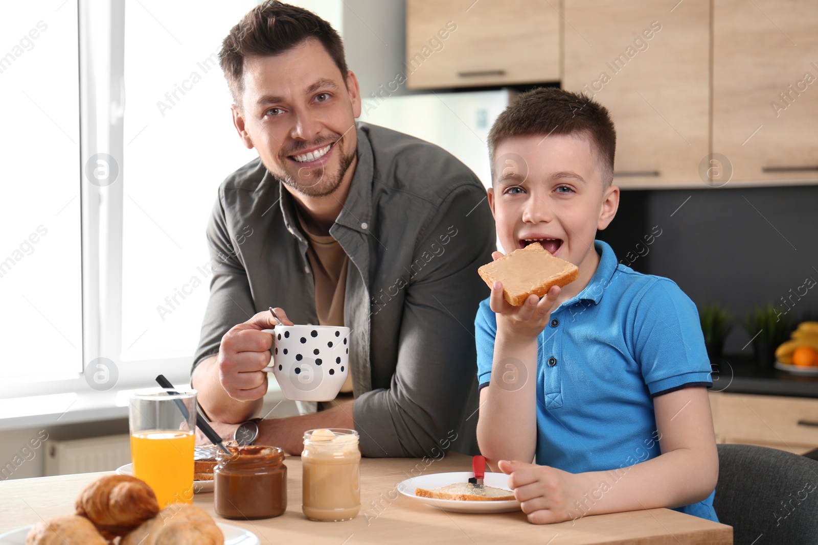 Photo of Dad and son having breakfast together in kitchen