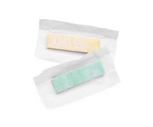 Photo of Unwrapped sticks of chewing gum on white background, top view