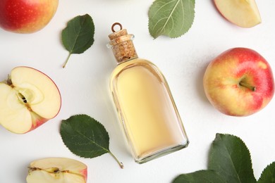 Natural apple vinegar and fresh fruits on white background, top view