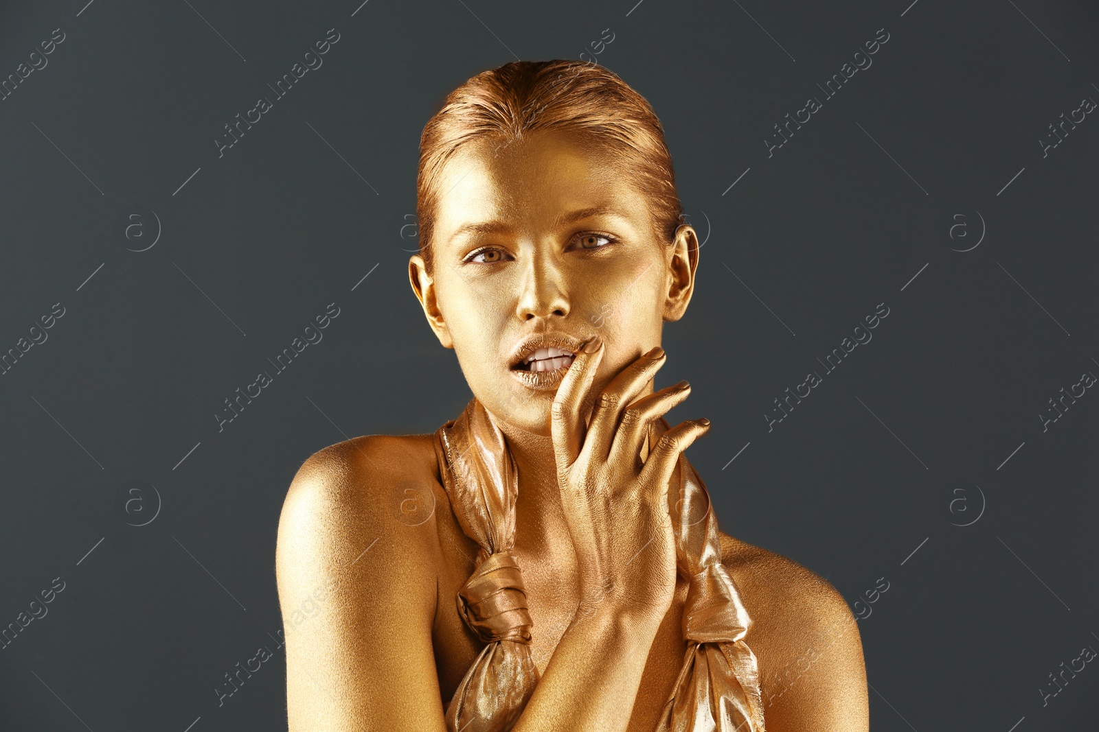 Photo of Portrait of beautiful lady with gold paint on skin against grey background