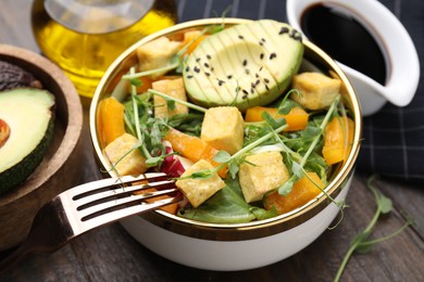 Photo of Delicious salad with tofu and vegetables on wooden table, closeup