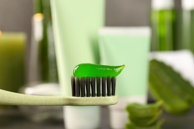 Aloe vera toothpaste on brush against blurred background, closeup