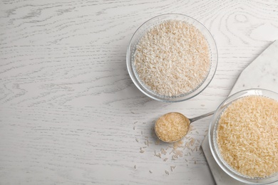 Photo of Flat lay composition with different types of rice and space for text on wooden table