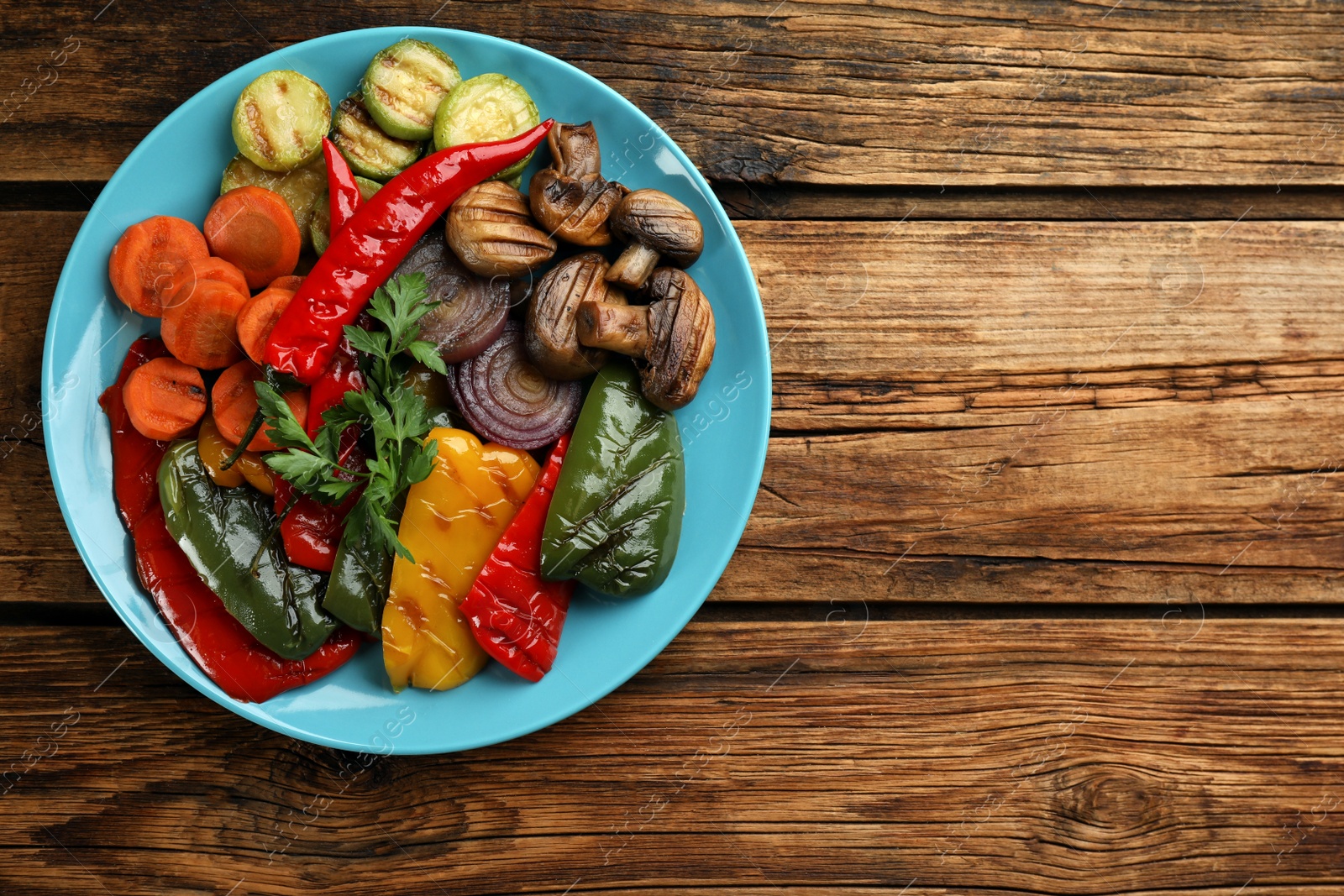 Photo of Delicious grilled vegetables on wooden table, top view. Space for text