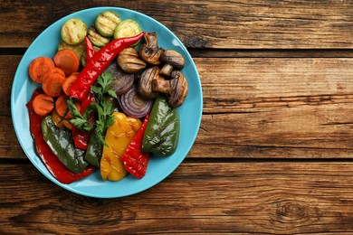 Delicious grilled vegetables on wooden table, top view. Space for text