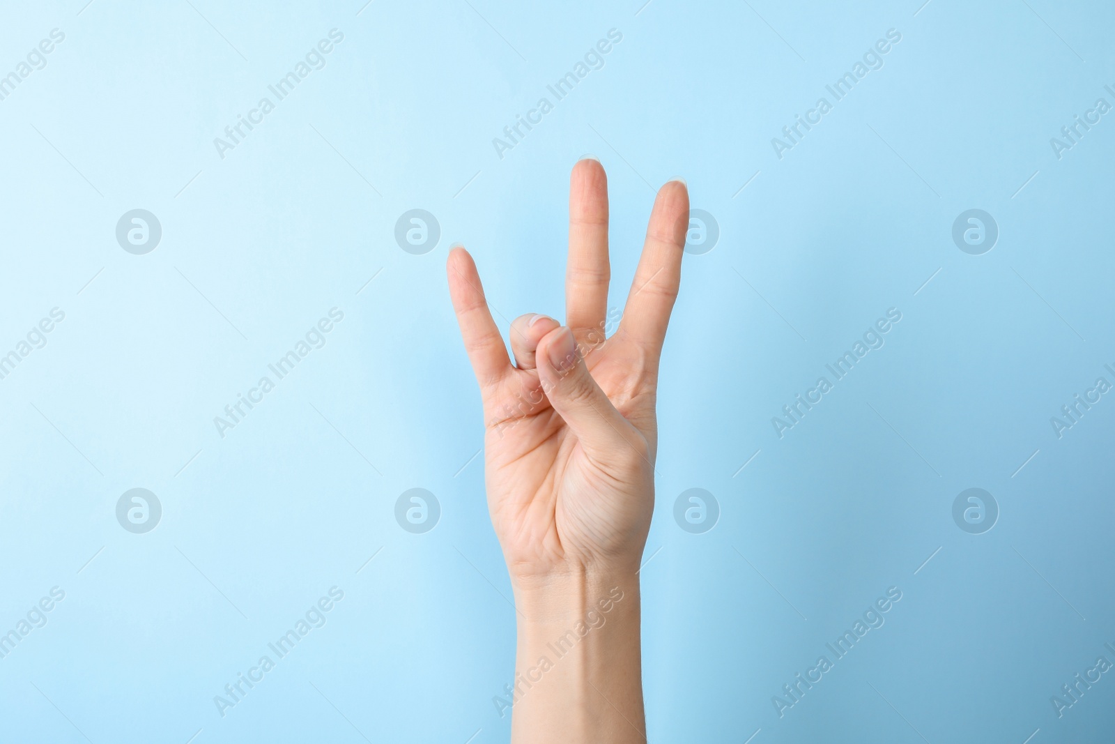 Photo of Woman showing number seven on color background, closeup. Sign language