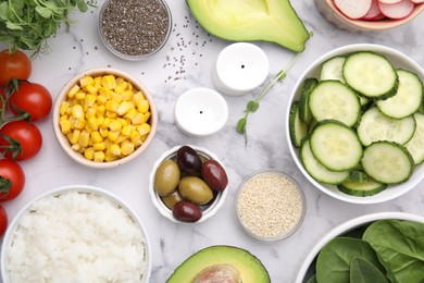 Photo of Ingredients for poke bowl on white marble table, flat lay