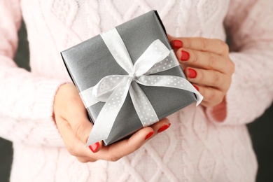 Woman holding beautiful Christmas gift with bow, closeup