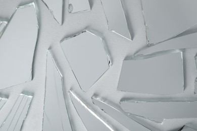 Photo of Shards of broken mirror on white background, top view