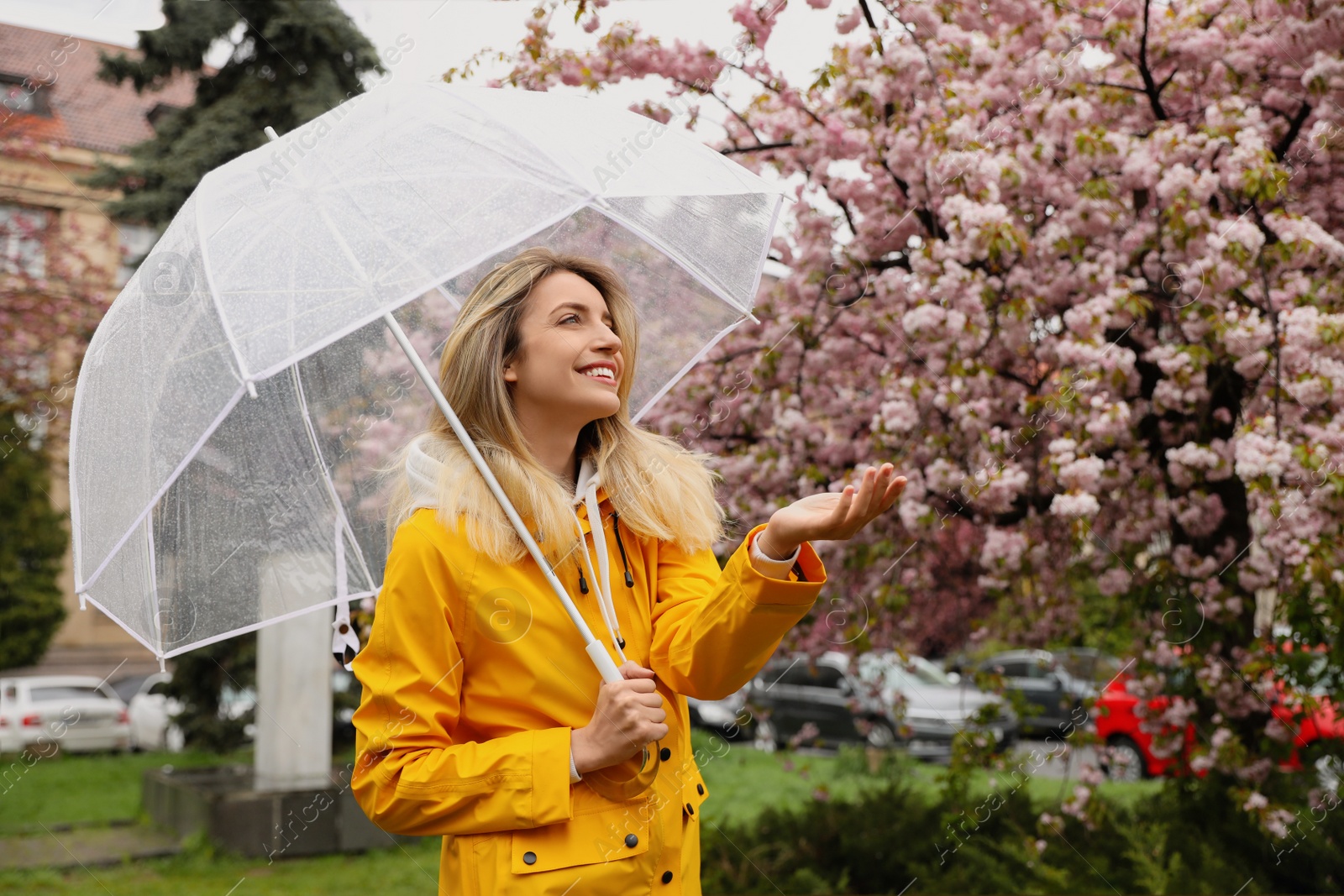 Photo of Young woman with umbrella in park on spring day