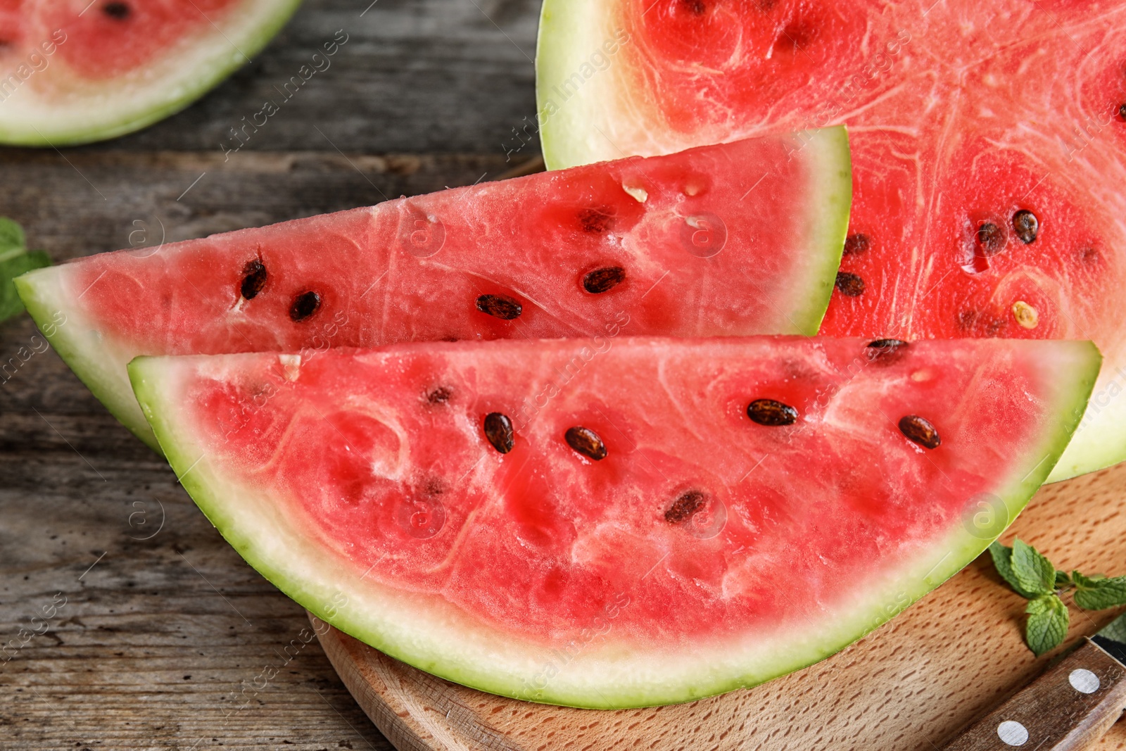 Photo of Wooden board with juicy watermelon slices on table