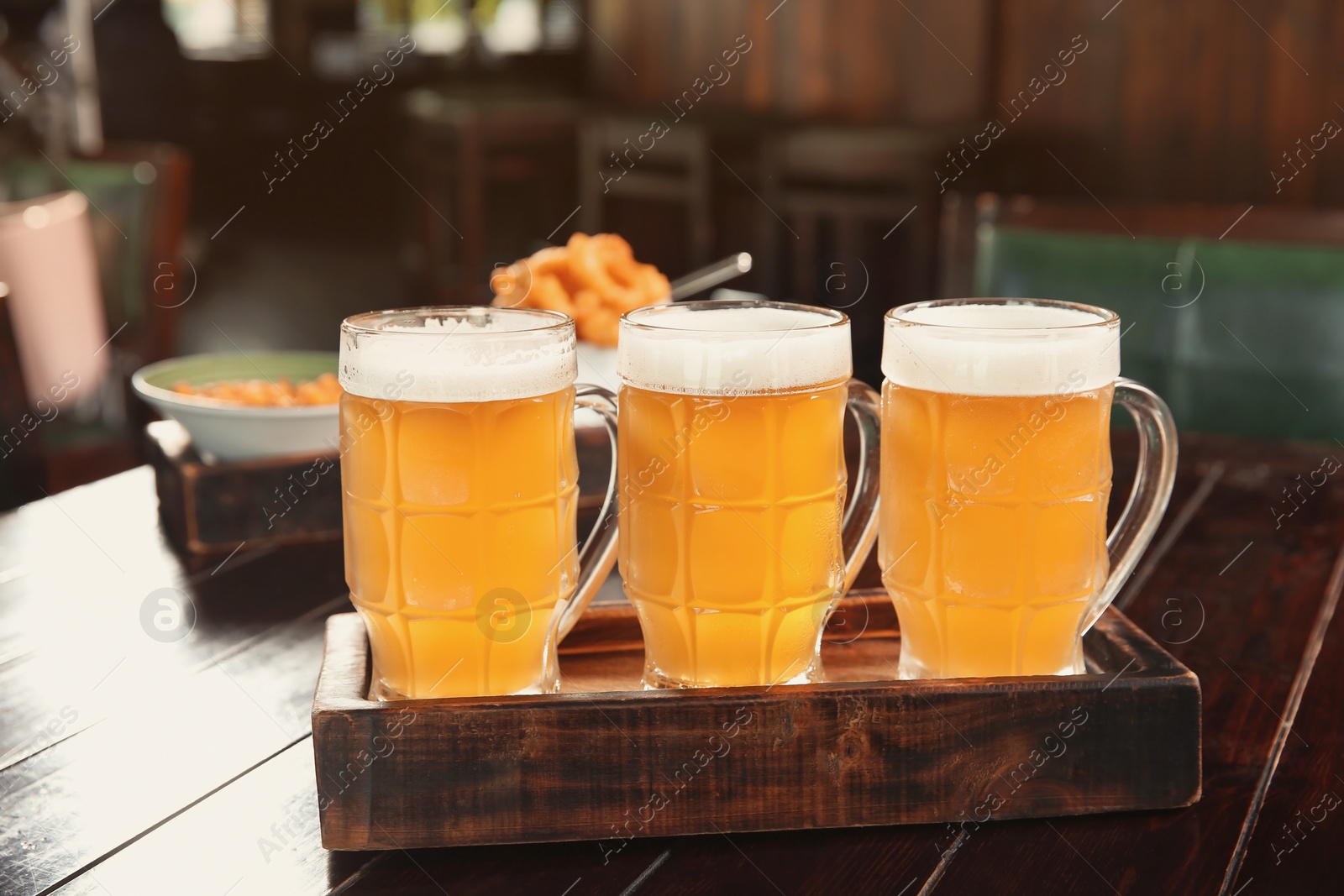 Photo of Glasses of tasty beer on wooden table in bar