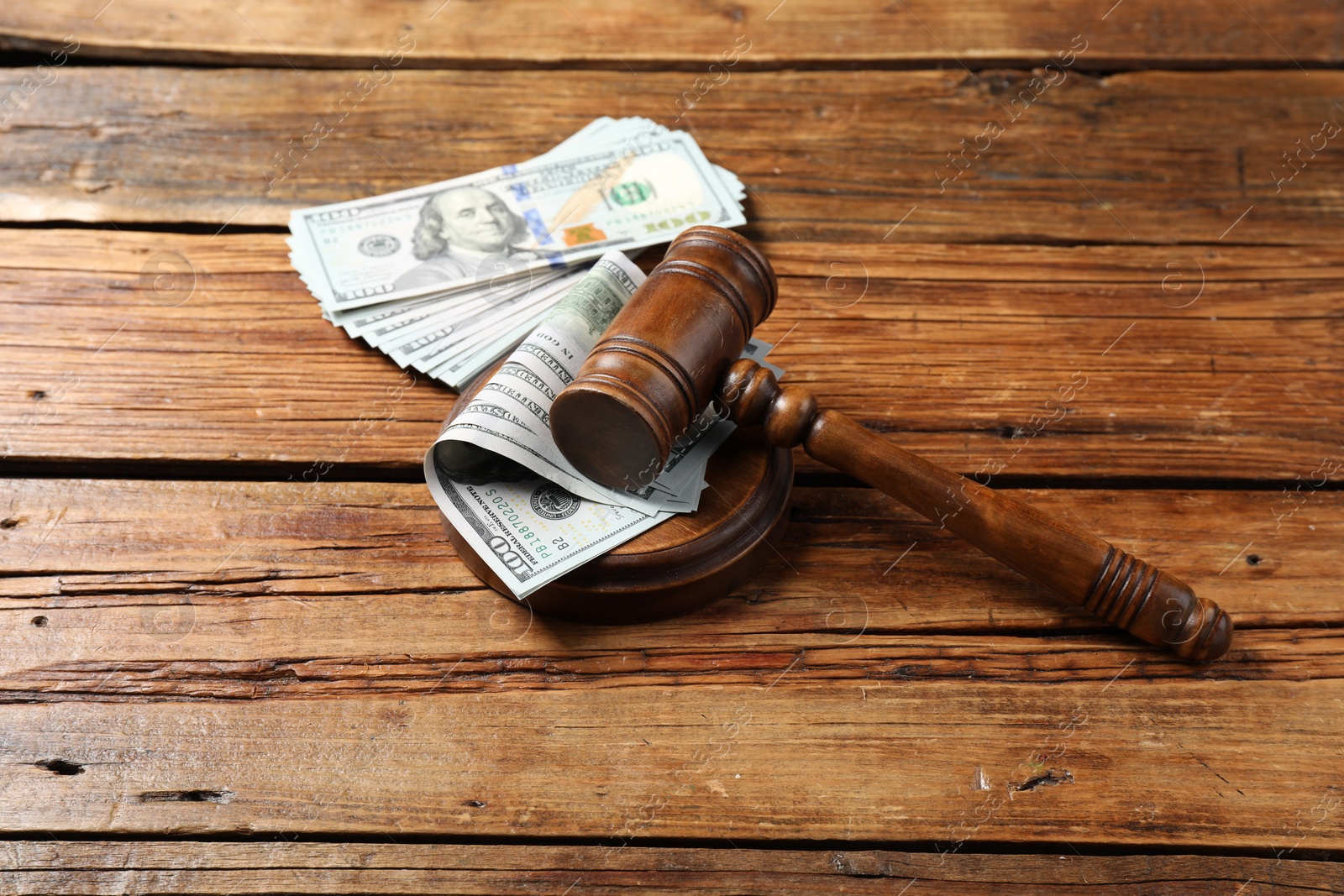 Photo of Judge's gavel and money on wooden table