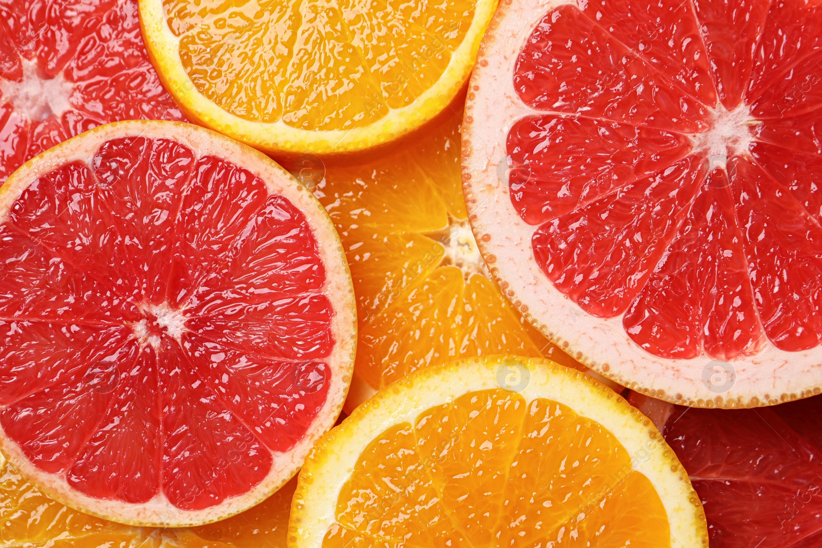 Photo of Slices of grapefruit and orange as background, top view