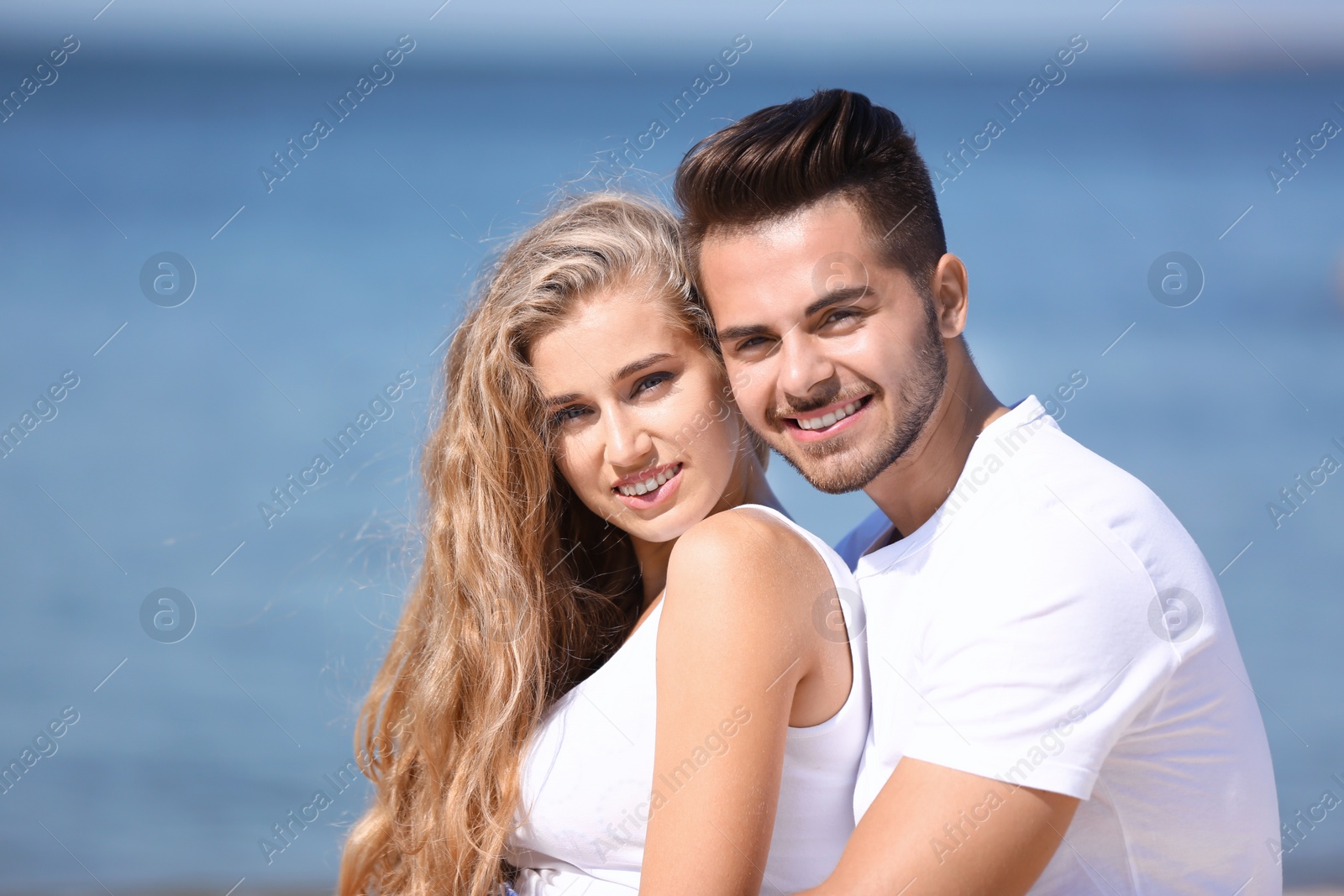 Photo of Happy young couple at beach on sunny day