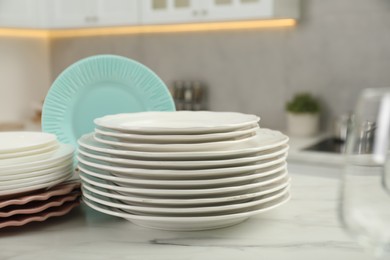 Clean plates on white marble table in kitchen