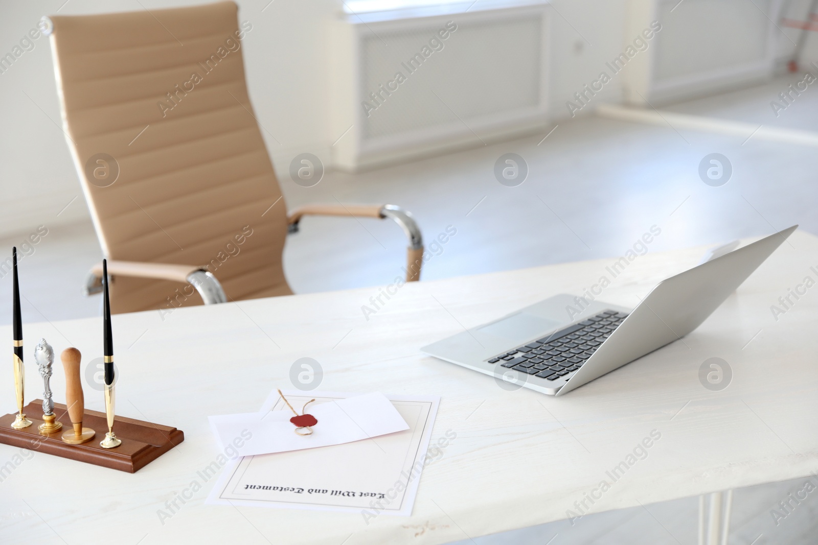 Photo of Wax stamps, laptop and documents on desk in notary's office