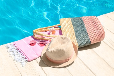 Photo of Beach accessories on wooden deck near swimming pool