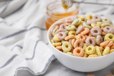 Photo of Tasty cereal rings in bowl on table, closeup. Space for text