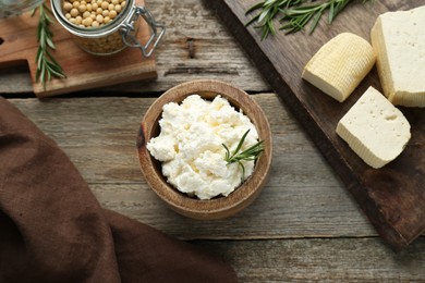 Photo of Delicious tofu cheese with rosemary and soy beans on wooden table, flat lay