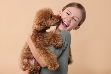 Photo of Emotional little child with cute puppy on beige background. Lovely pet