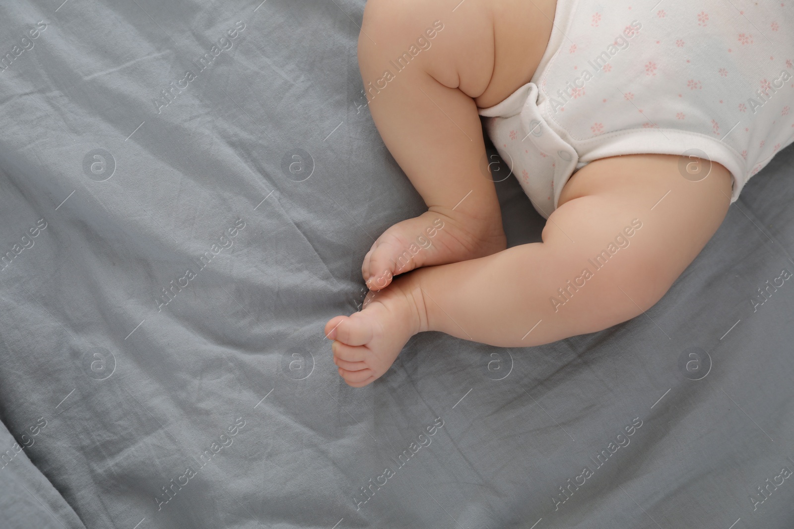 Photo of Little baby on bed, top view. Space for text