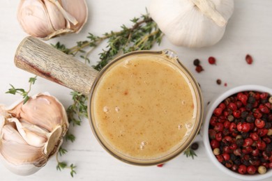 Photo of Delicious turkey gravy, garlic, thyme and peppercorns on white table, flat lay
