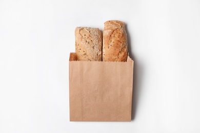 Paper bag with bread loaves on white background, top view. Space for design