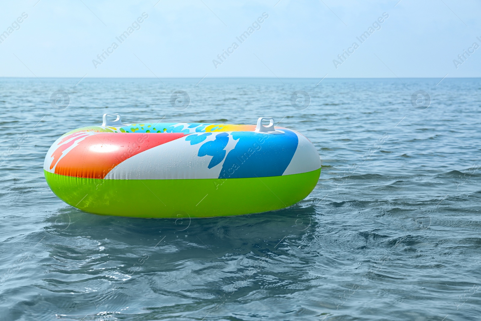 Photo of Bright inflatable ring floating on sea water. Summer vacation