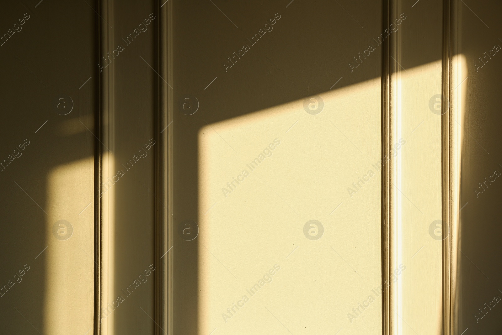 Photo of Light and shadow from window on beige wall indoors