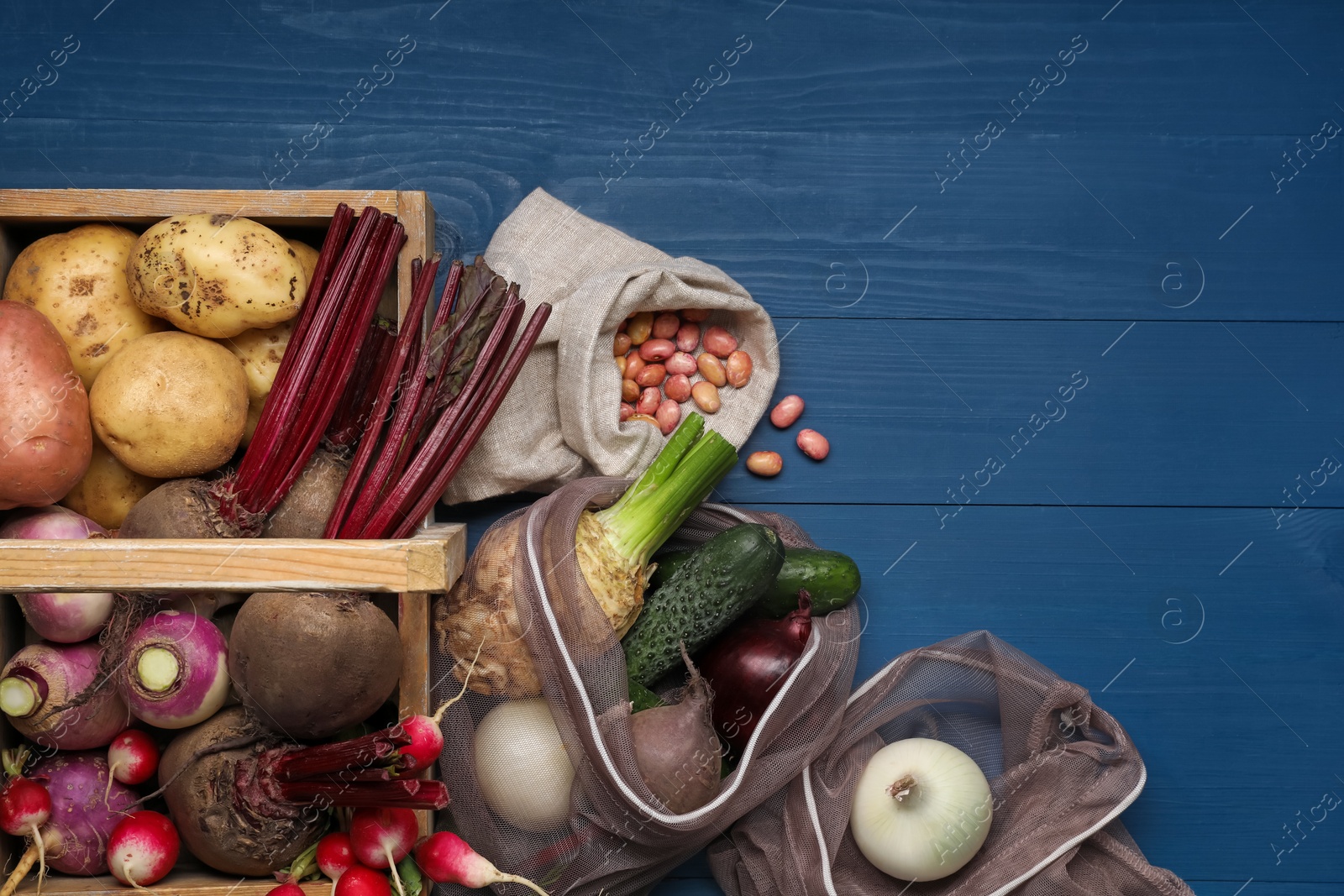 Photo of Different fresh ripe vegetables on blue wooden table, flat lay. Space for text
