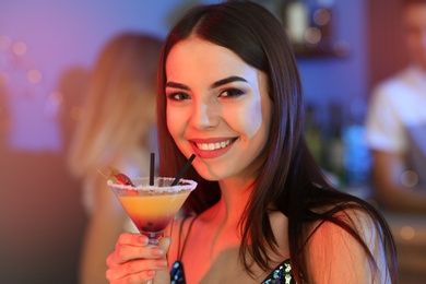 Photo of Beautiful young woman with glass of martini cocktail in bar