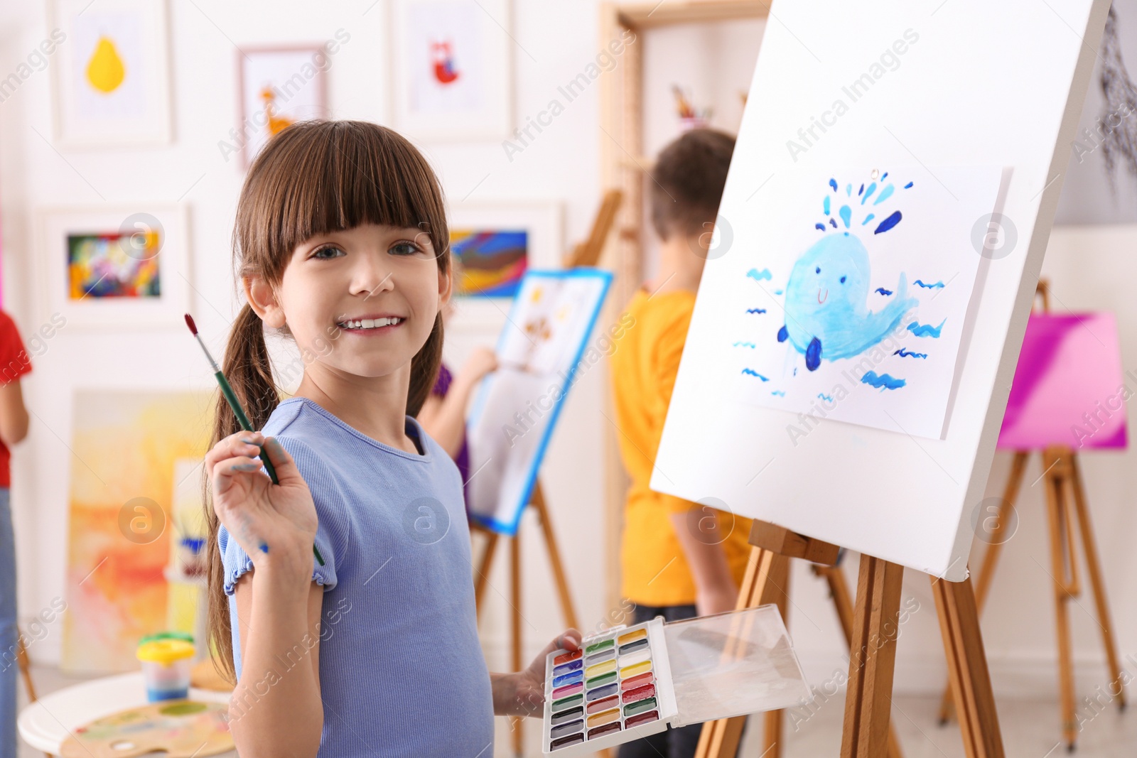 Photo of Cute little child painting during lesson in room