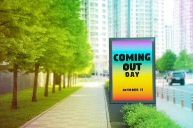 Text National Coming Out Day, October 11 with rainbow background on advertising board outdoors