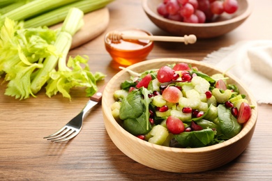 Photo of Delicious fresh celery salad served on wooden table